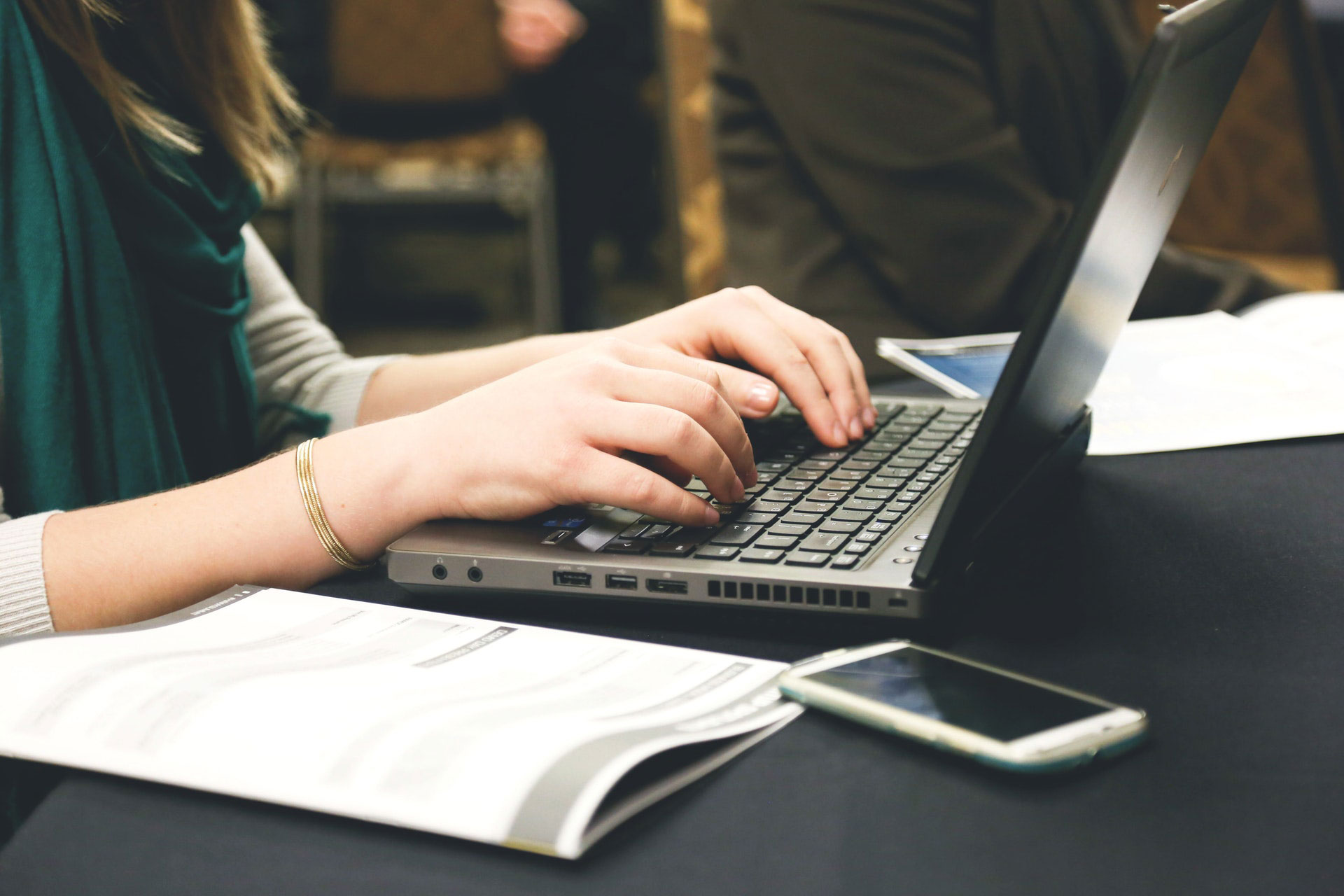 pessoa digitando em um notebook uma informação jornalística seguindo as boas práticas de intertítulo