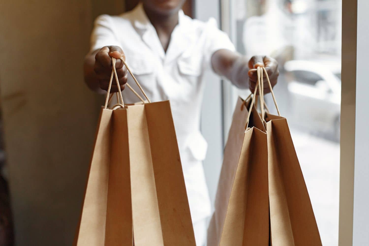 Imagem de uma pessoa segurando sacolas de compra representando desejo, necessidade e demanda
