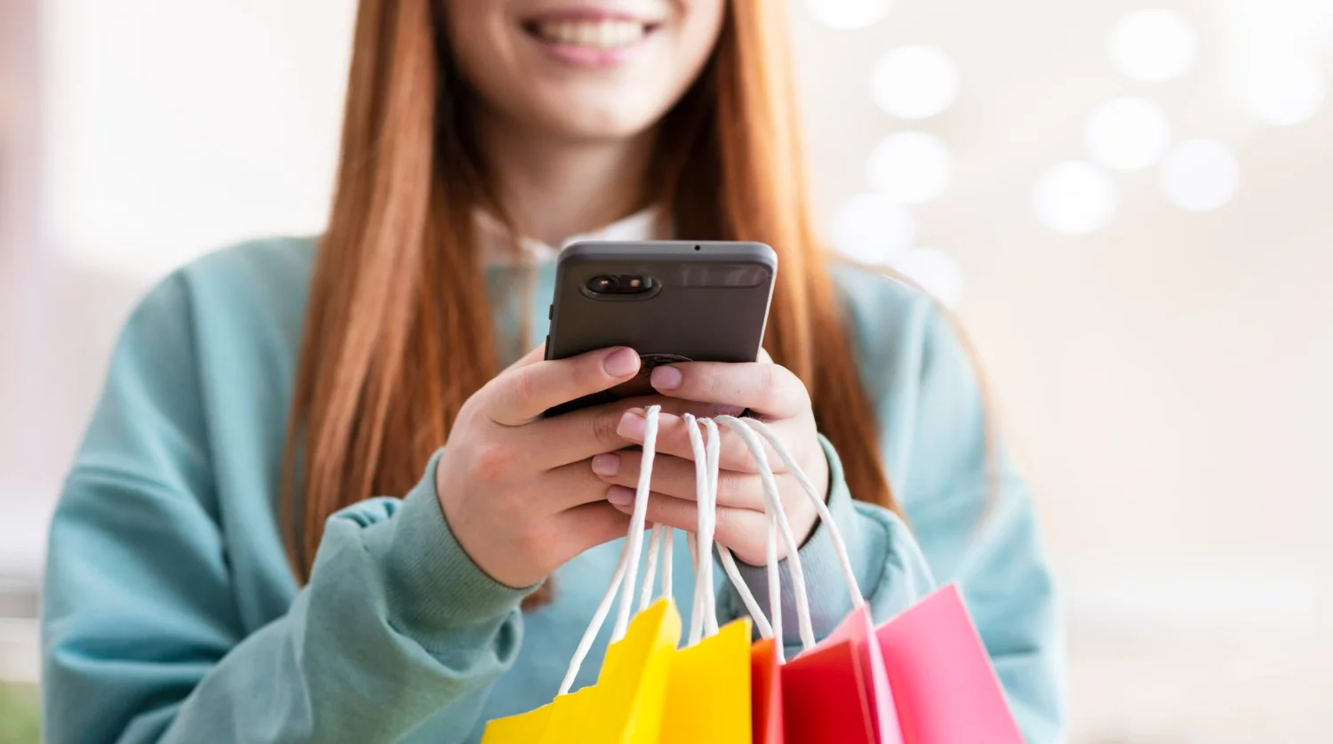 Mulher no celular analisando as tendências de consumo para 2024