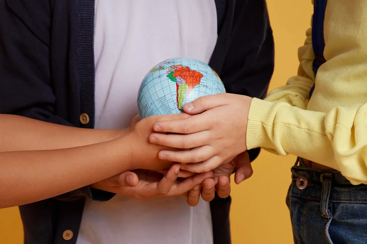 Pessoas segurando o globo com as mãos representando o intercâmbio voluntário